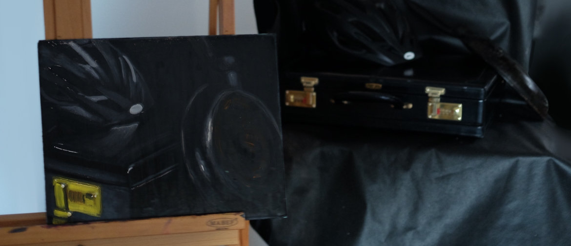 Dark-on-dark still life emerging from shadow, in the studio beside its setup.